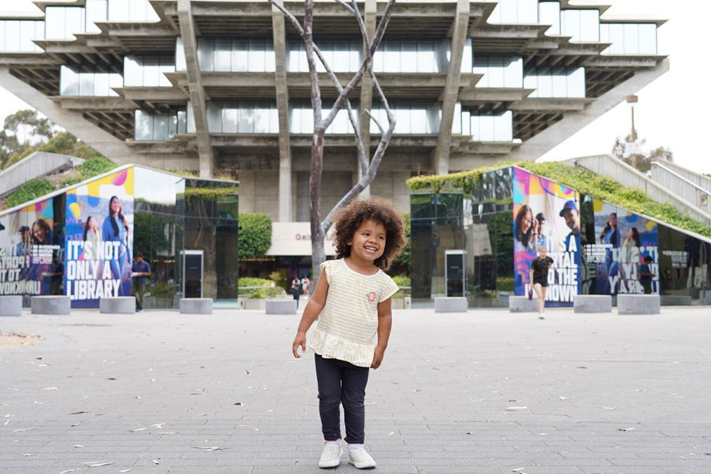 Small child stands in front of Geisel Library
