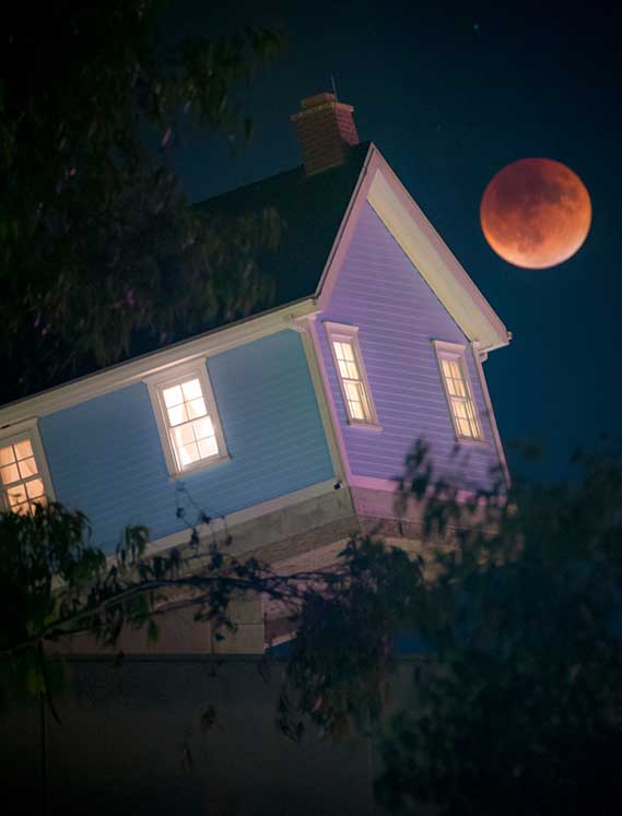 Photo of the Fallen Star House at night with full moon