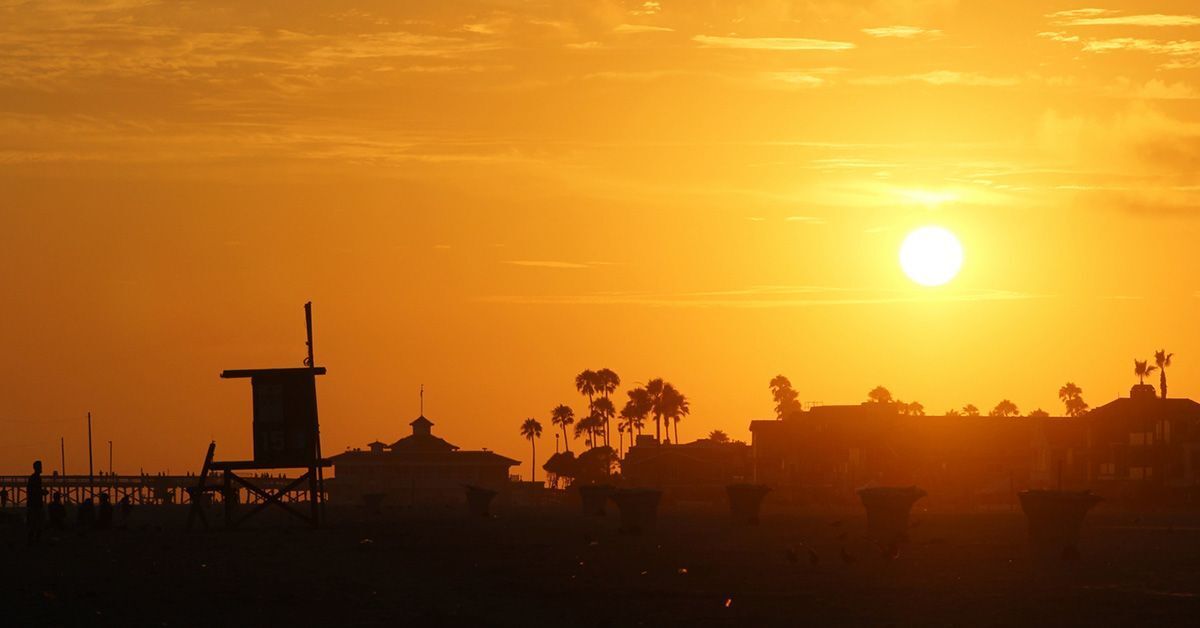 Silhouette of lifeguard stand against setting sun