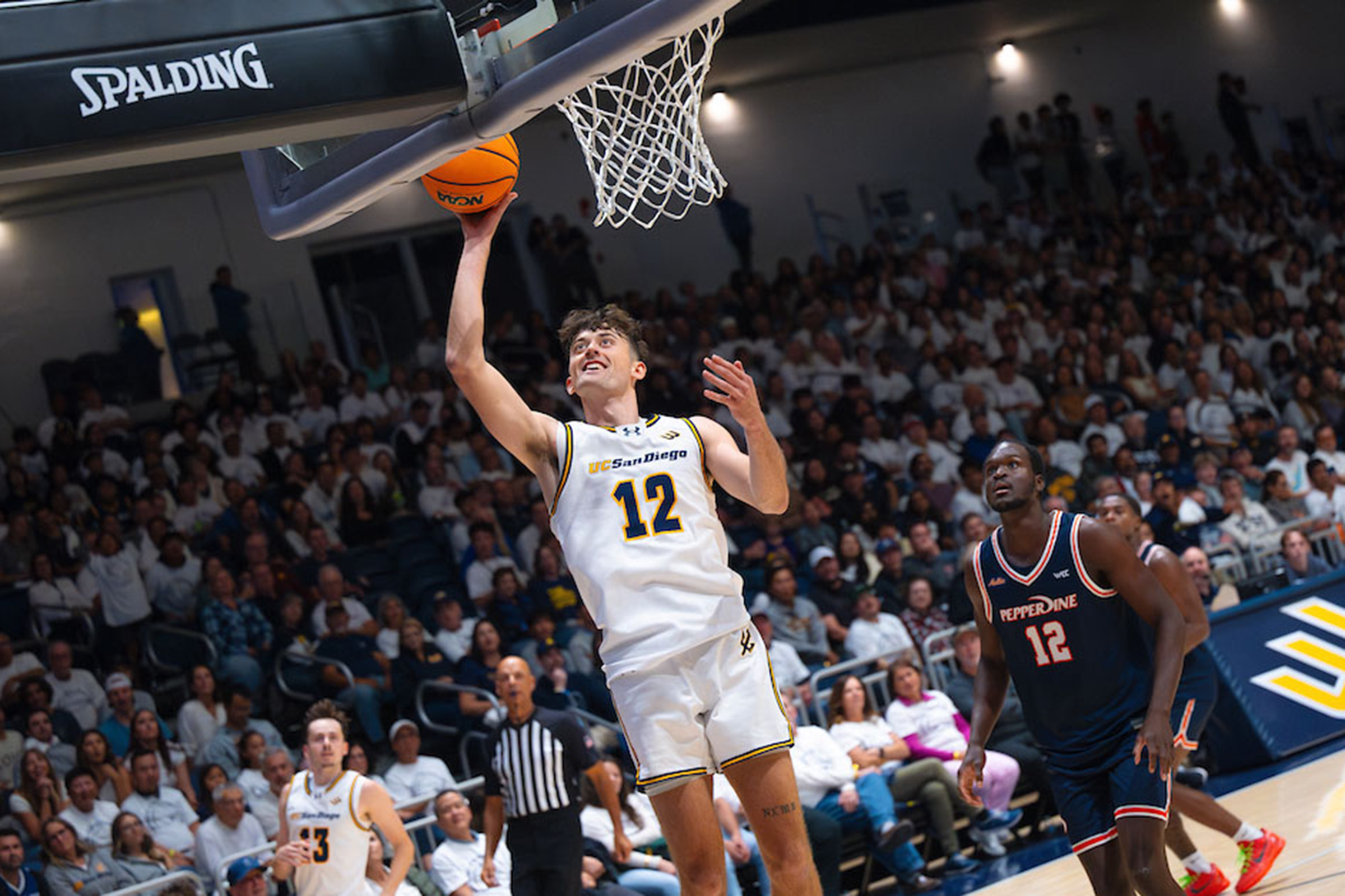 Triton basketball player shoots ball at rim