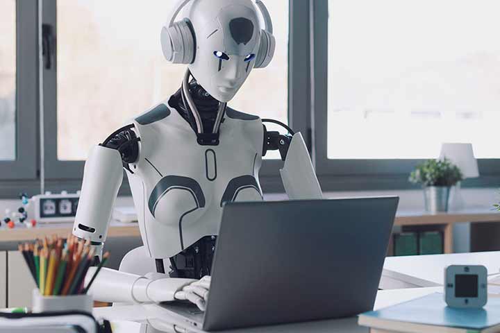 Humanoid robot wearing headphones working at laptop